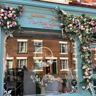 The flower-framed shopfront of The Hair Room on Montague Road
